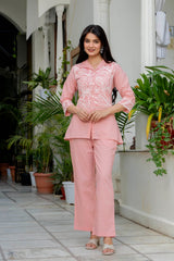 Front-button embroidered tunic shirt paired with full-length straight trousers for women.